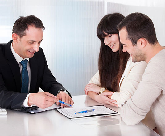 A couple of people sitting at a table with papers